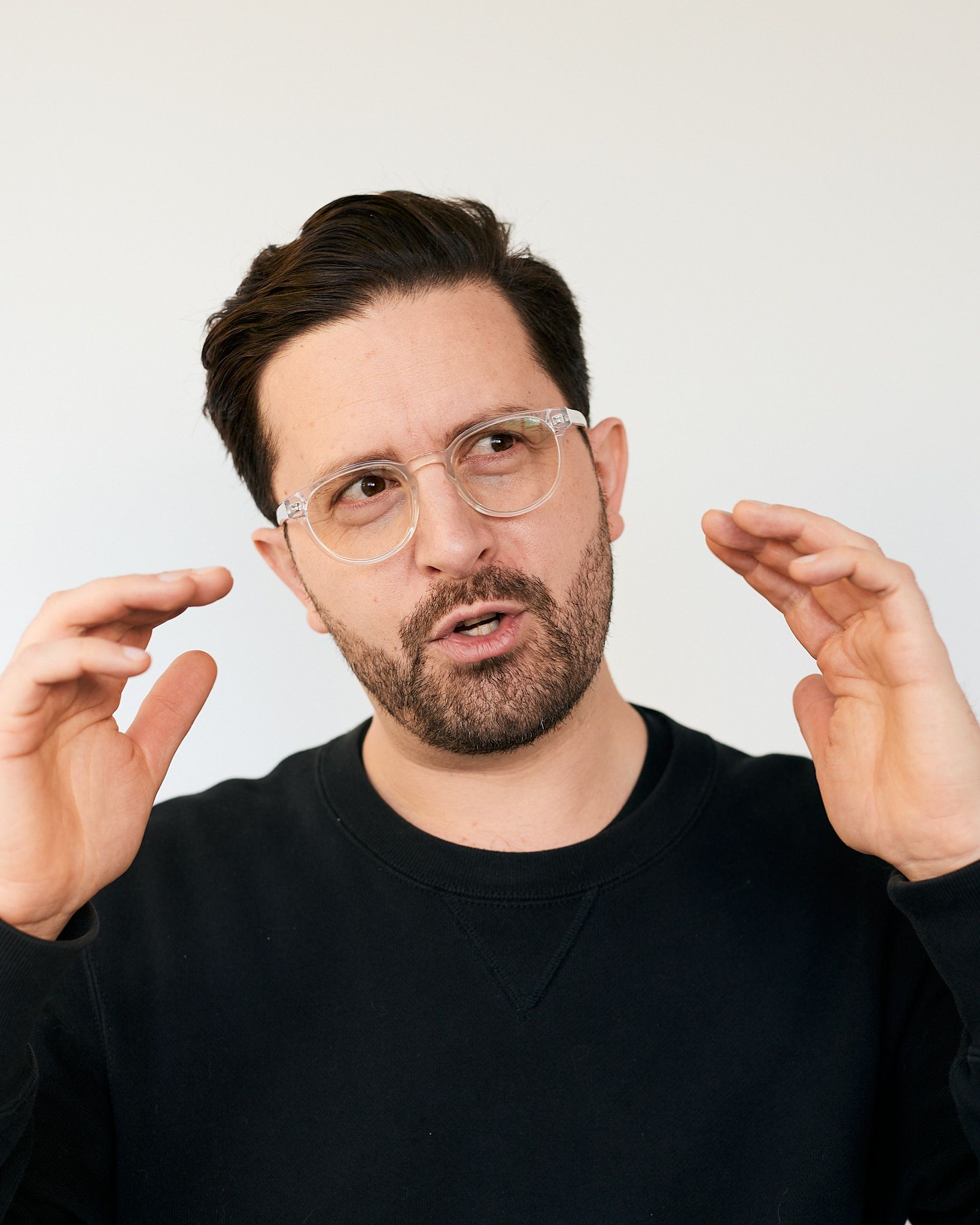 Portrait photo of Alex holding a photography gray card and making a silly face